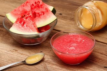 Water melon face mask for natural beauty. Edible cosmetic from fresh melon and honey on wooden board