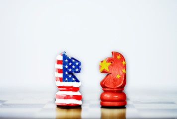 USA flag and China flag print screen on horse chess with white background.It is symbol of tariff...