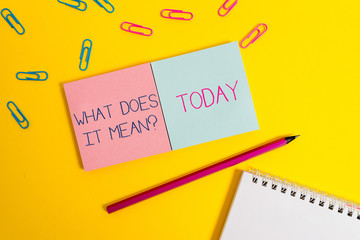 Handwriting text What Does It Mean question. Conceptual photo intended to communicate unclear statement Colored square blank sticky spiral notepads pencil clips color background