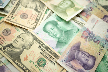 Select focus of 10 US dollar stack under China yuan banknote. Concept of Trade war between the United States and China.