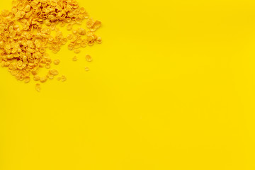 cereals, oatflakes and cornflakes for healthy breakfast on yellow background top view mock up