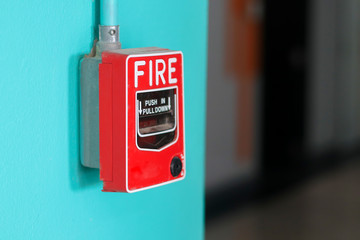 Fire alarm switch on the green wall in factory.