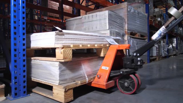 Close-up leaves the pallet on the lift. Logistics warehouse. 4K Slow Mo