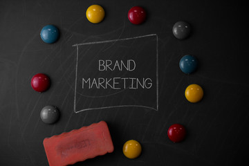 Text sign showing Brand Marketing. Business photo text Creating awareness about products around the world Round Flat shape stones with one eraser stick to old chalk black board