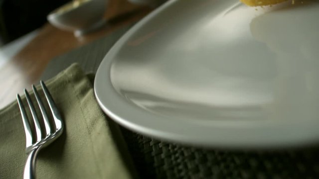 The delicious, golden nuggets fall nicely on a porcelain plate.  Very beautiful studio shot. Slow motion. Camera Phantom Flex 4K.