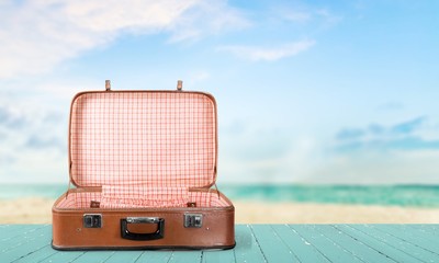 Retro suitcase with travel objects  on sea background