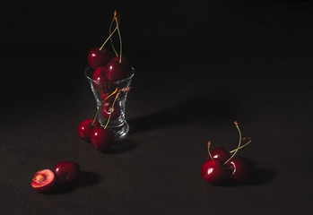 Still life of fresh delicious sweet cherry in a glass on dark background. Low key. © LanaUst
