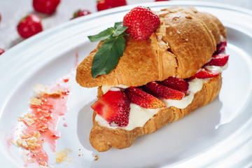 Tasty Croissant Cut Two with Cream and Strawberry. Homemade or Restaurant Fresh Baked Cake with Custard and Ripe Organic Berries on White Plate. French Delicious Crunchy Lunch Dessert