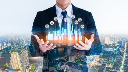 Businessman hand holding a Smart city with smart services and icons, internet of things, networks and conection concept.Hand holding city hologram and wireless icon.