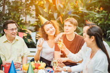 Family and Friends Gathered Together at the Table.Cooking bbq outdoor for a group of friends.Big Family Garden Party Celebration.Diverse Neighbors Drinking Party Yard Concept.