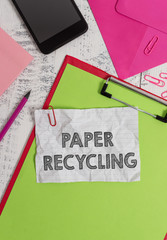 Conceptual hand writing showing Paper Recycling. Concept meaning Using the waste papers in a new way by recycling them Clipboard sheet pencil smartphone clips notepad wooden back