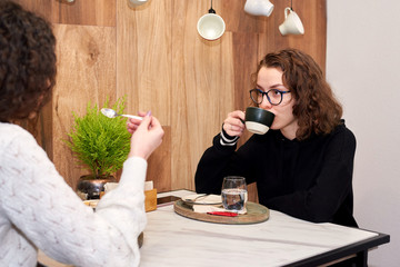 Two curly caucasian high school girls having a conversation