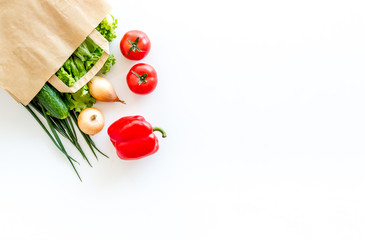Healthy food with fresh vegetables in paper bag on white background top view space for text
