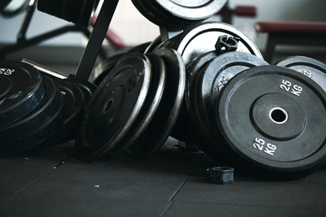 Obraz na płótnie Canvas Gym equipment for work out. Gym pancakes scattered around the gym.