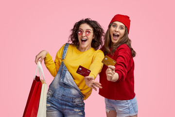 Cheerful friends with credit cards during shopping