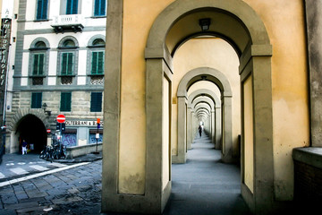 Fototapeta na wymiar Arched passage under the historic building of the Vasari Corridor along the embankment of the Arno River. Florence, Tuscany, Italy. April 2012
