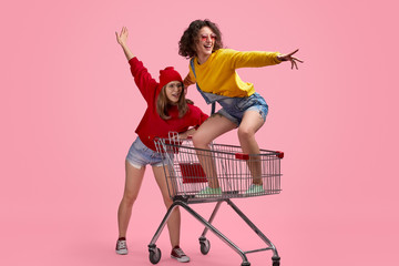 Best friends riding shopping cart