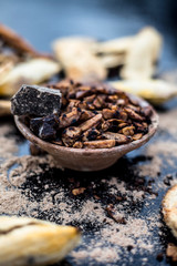 Popular Indian and Asian mukhwas or mouth freshener i.e. Aam Ki Ghuthli Ka Mukhwas consisting of ghee and hard-boiled mango seeds in a bowl on a wooden surface.Along with some raw dried mango seeds.