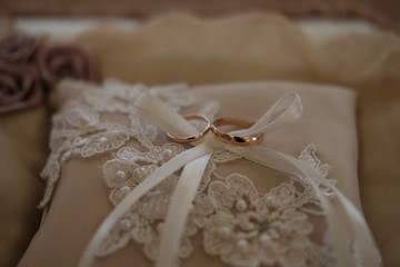  two wedding rings are on the lace pad