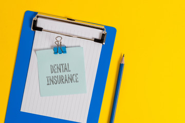 Handwriting text writing Dental Insurance. Conceptual photo form of health designed to pay portion or full of costs Clipboard holding blank paper sheet note binder pencil colored background