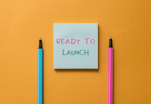 Text sign showing Ready To Launch. Business photo showcasing an event to celebrate or introduce something new to market Front view blank colored sticky note two ballpoints cool yolk background