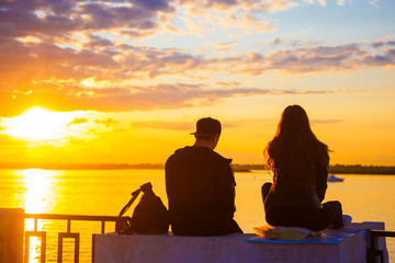 The two lovers looked out at the water during sunset.