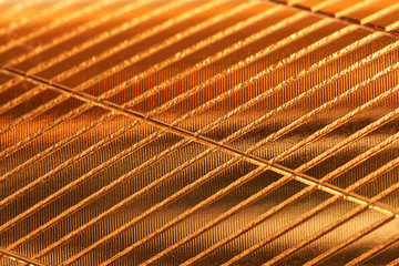 Sheet metal with a golden shade and diagonal notches. Background and pattern