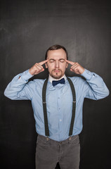 Handsome teacher or business man thinking on blackboard