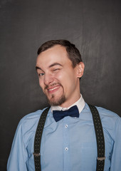 Handsome business man winking on blackboard