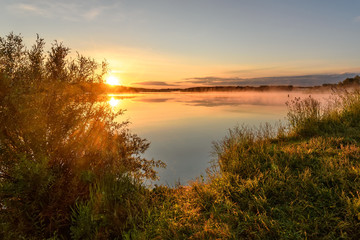 Fototapeta na wymiar lake sunrise sun fog grass