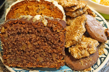 Christmas muffins with nuts and biscuits with powdered sugar on a decorative blue plate on the Christmas table