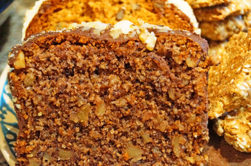 Christmas muffins with nuts and biscuits with powdered sugar on a decorative blue plate on the Christmas table