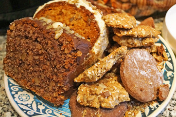 Christmas muffins with nuts and biscuits with powdered sugar on a decorative blue plate on the Christmas table