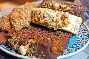 Christmas muffins with nuts and biscuits with powdered sugar on a decorative blue plate on the Christmas table