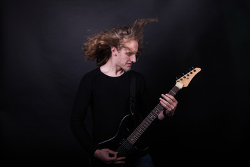 Obraz premium Young caucasian adult playing guitar in the studio