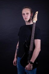 Fototapeta premium Young caucasian adult with long hair playing guitar
