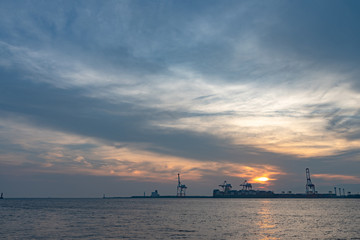 Naklejka premium Osaka bay with Yumeshima island on background in summer sun set time, view from Osaka metro Cosmosquare train station park promenade