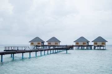 Water Villas and wooden bridge at Tropical beach in the Maldives