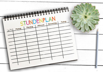 top view of class schedule or timetable template with German word STUNDENPLAN on notepad against...