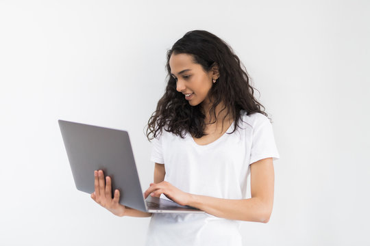 Thoughtful young woman using laptop on white background