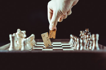 Hand of business man moving chess to Building and house models in chess game, competition success play. strategy, management or leadership concept