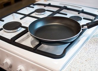 Empty frying pan on a gas stove burner