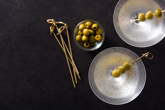 Classic Dry Martini with olives isolated on black background. Top view. Copyspace