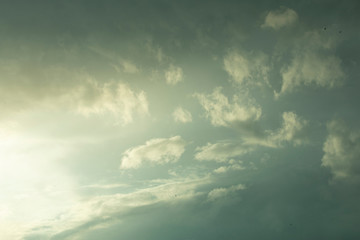 cloudy gray stormy sky with shining light from the setting sun