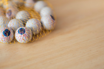 halloween eyes, with veins, inside a net, on wooden background.