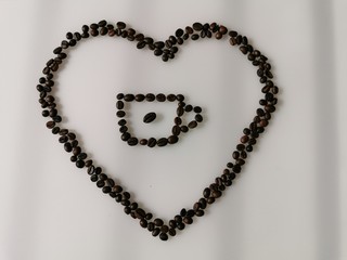 A heart of coffee beans with coffee mug