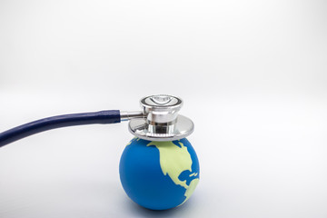 Global Health Care, Environment Ecology, Earth Concept. Close up of doctor Stethoscope on mini world ball on white background and copy space for text.