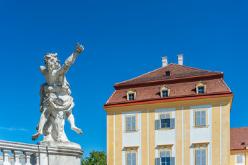 Baroque statue in a park with historical building