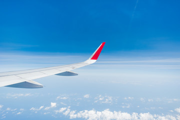 Fototapeta na wymiar aircraft Wing on cloudscape and blue sky