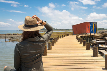  Una mujer con sombrero observa un paisaje de palafitos en Carrasqueira, un puerto pesquero en Portugal